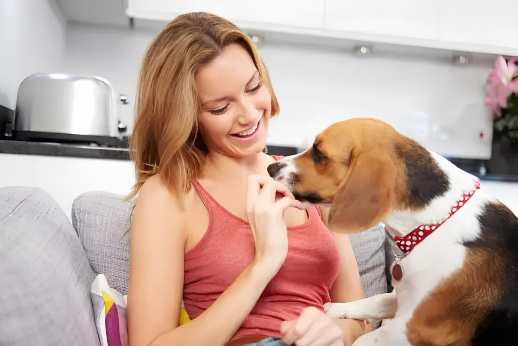 um mulher dando um comprimido de omeprazol para seu cachorro.