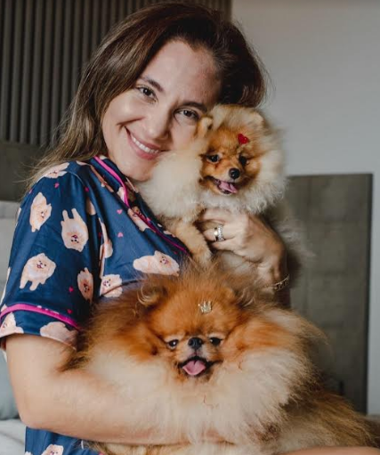 uma mulher com seu cachorro da raça Lulu da Pomerânia.