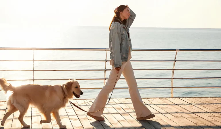 uma mulher passeando com seu cachorro.