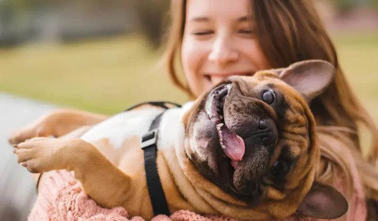 uma menina com seu cachorro no colo.