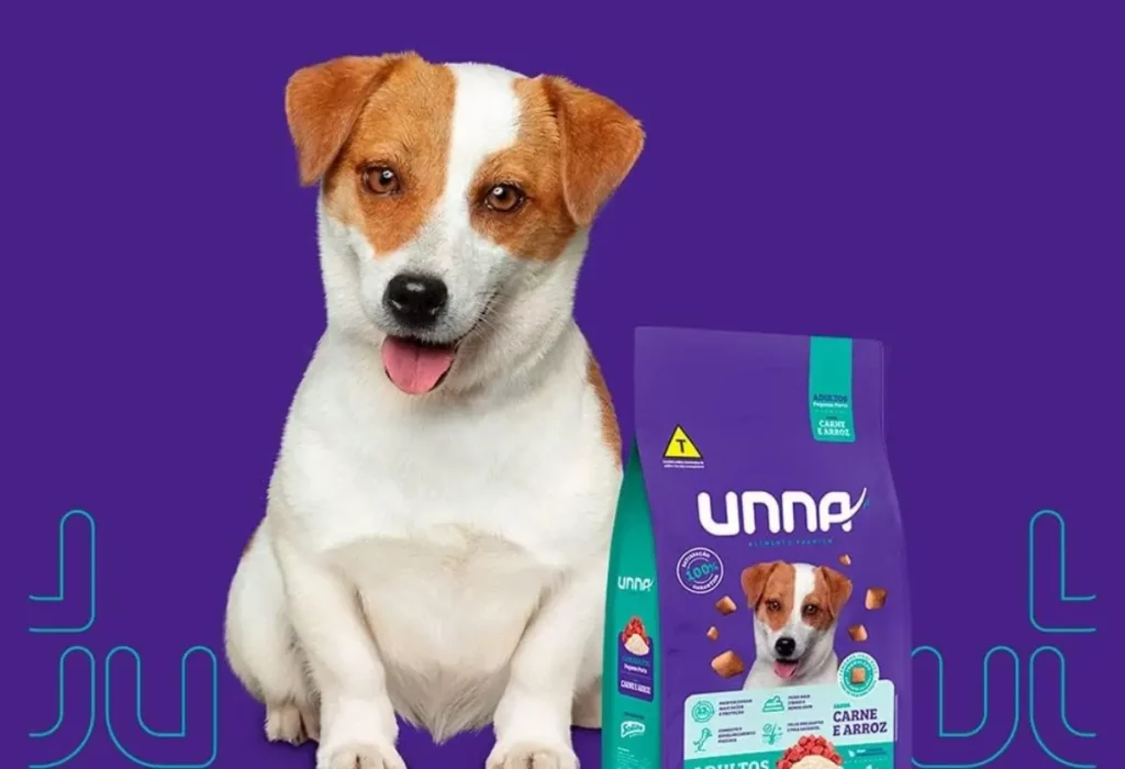 um cachorro sentado e ao seu lado um pacote de ração da marca UNNA.